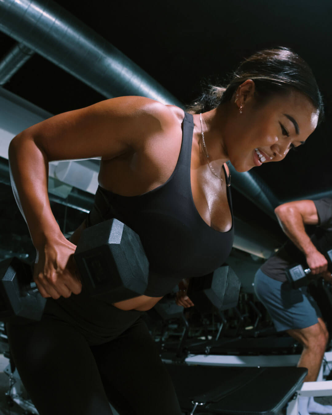 Member rowing a dumbbell